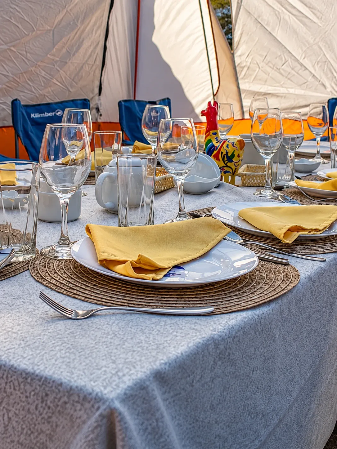 A laid table with glassware inside a dining tent